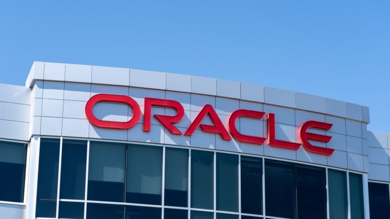 Modern exterior view of the Oracle headquarters building with the red Oracle logo, representing enterprise technology and cloud computing.