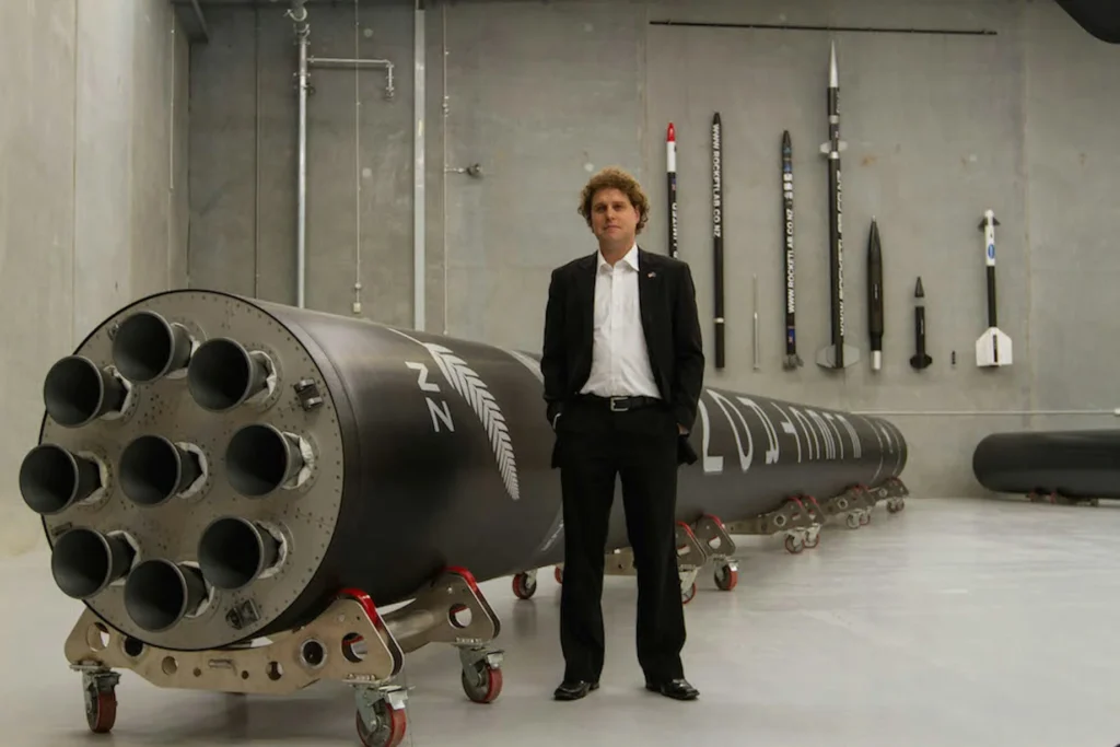 Rocket Lab founder Peter Beck standing beside the Neutron rocket booster inside Rocket Lab’s aerospace manufacturing facility
