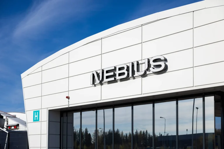 Nebius data centre building with the company logo displayed on a modern white exterior under a blue sky.